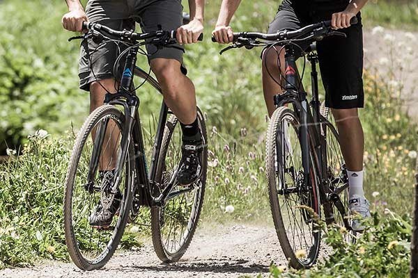 two cyclists riding hybrid bikes off-road