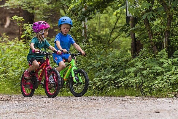 two kids riding a bikes