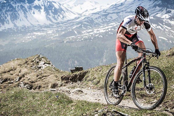 A cross country mountain biker riding through smooth terrain