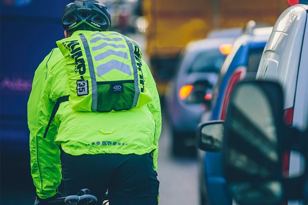 Commuter with a reflective, hi-viz jacket and backpack cover