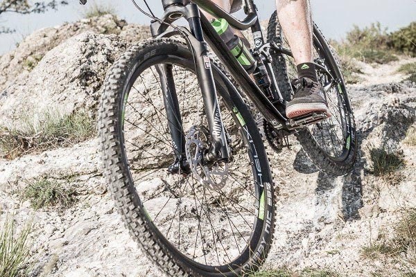 Knobbly wide mountain bike tyres on a rocky trail