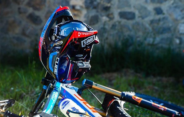 Full face helmet and google rest on the bars of a Cube Stereo