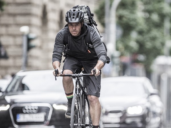 A guy in heavy urban traffic with a helmet on