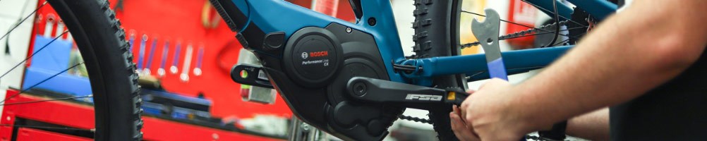 Tredz mechanic installing pedals on a Cube electric mountain bike