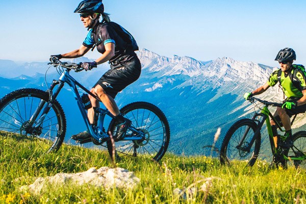 two mountain bikers riding in the mountains