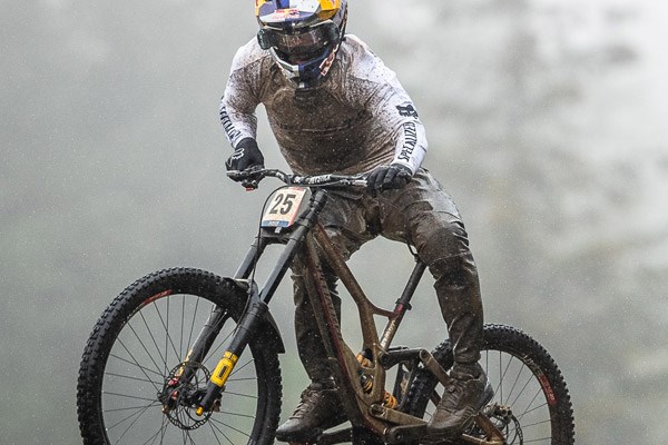 Elite DH racer Finn Iles wearing MTB trousers during a wet Fort William World Cup