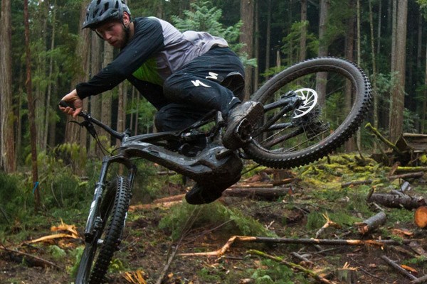 A mountain biker wearing Specialized DH trousers while whipping