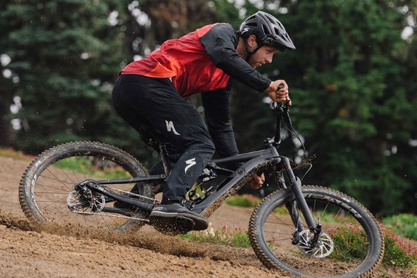 A mountain biker wearing a loose-fitting long sleeve jersey