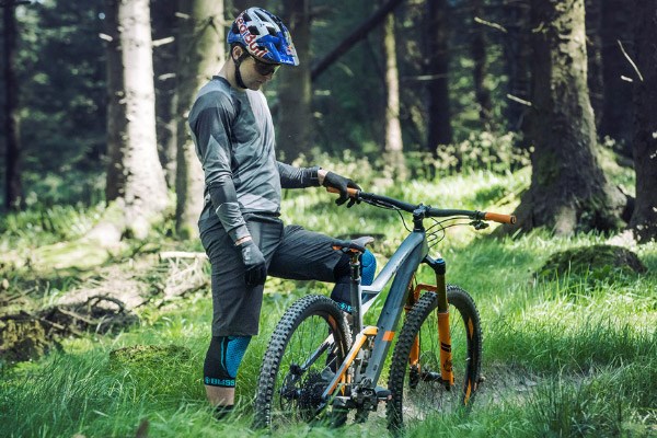 Mountain biker looking at the saddle on a Cube full-suspension MTB