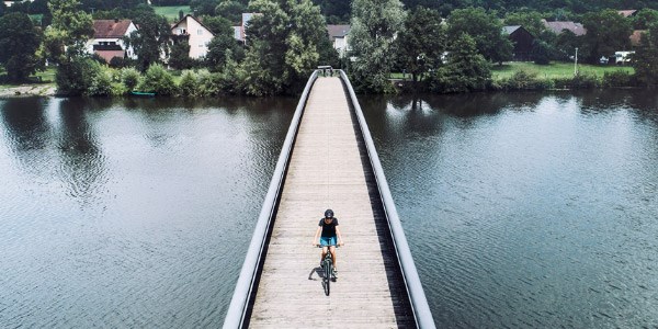 Cyclist crossing a bridge in a rural setting