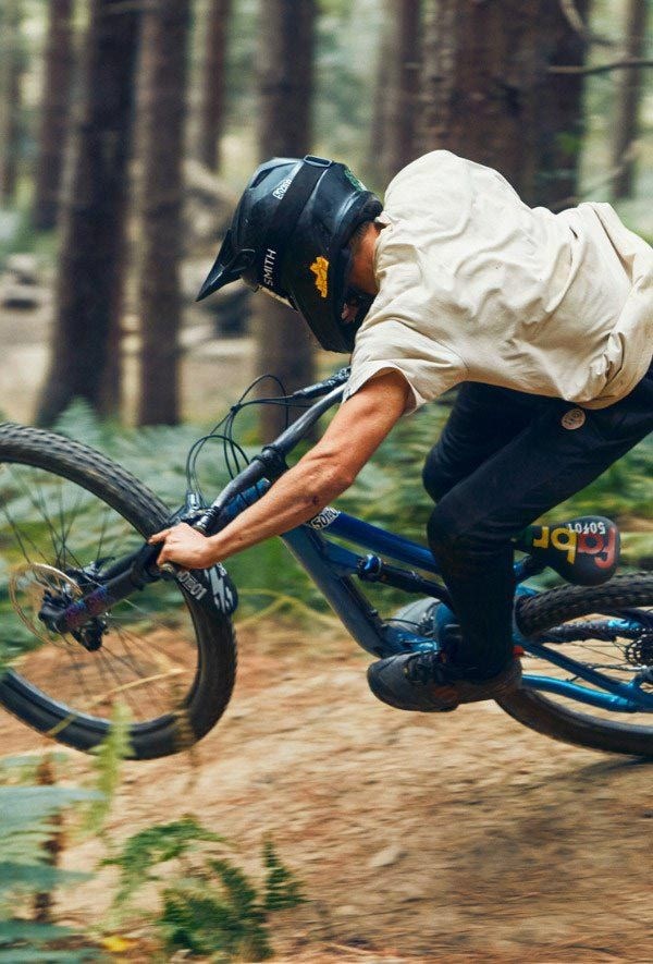 A mountain biker riding a full-suspension bike through flowing trails