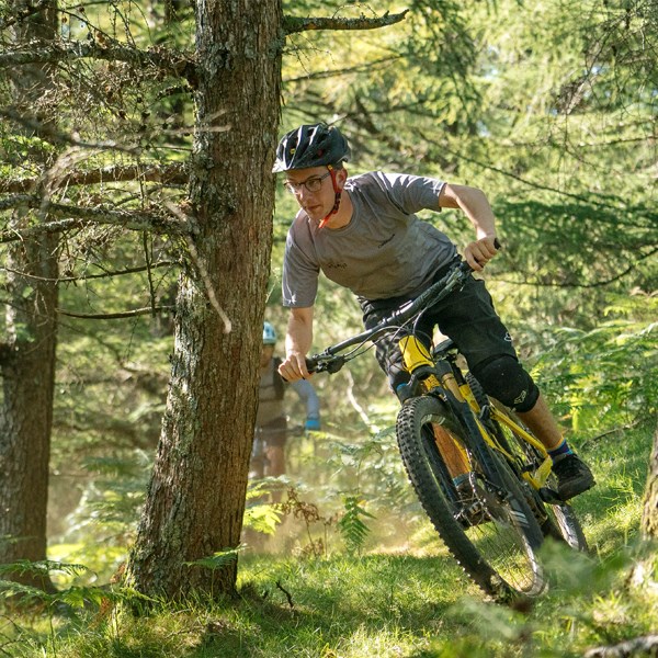 MTB rider descending through the woods on Orbea Wild FS in Spain