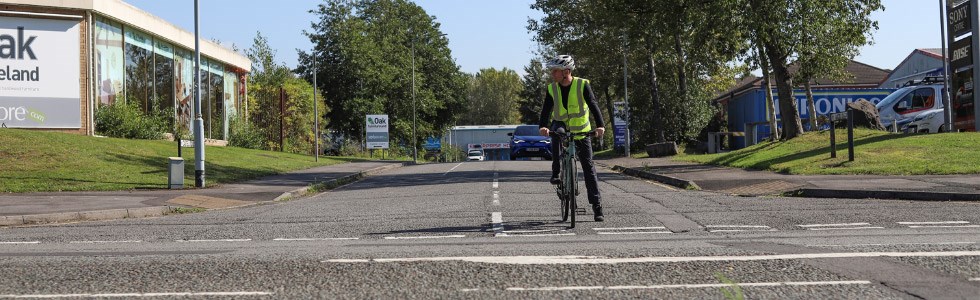 A cyclist gives way at a junction until all lanes are clear before turning right onto the main road