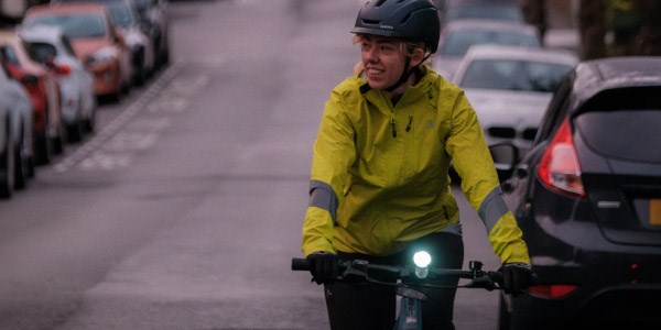 A cycle commuter riding through the city wearing high-vis clothing
