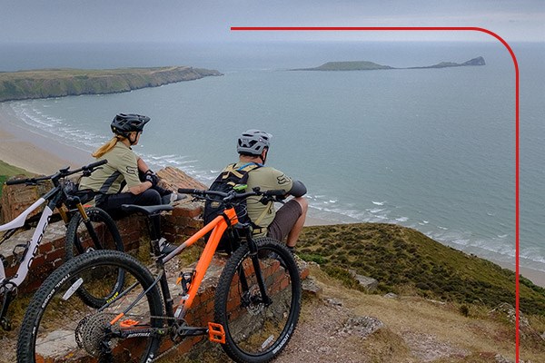 Two mountain bikers overlooking Rhossili Bay