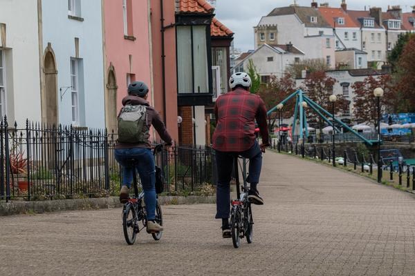 Two people riding Brompton folding bikes