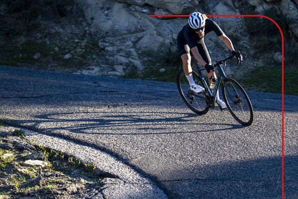 A road cyclist riding down a twisty descent
