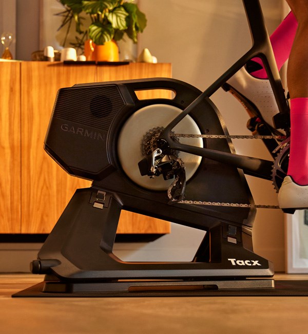 detail of the tacx neo rurbo trainer with road bike attached and rider pedalling