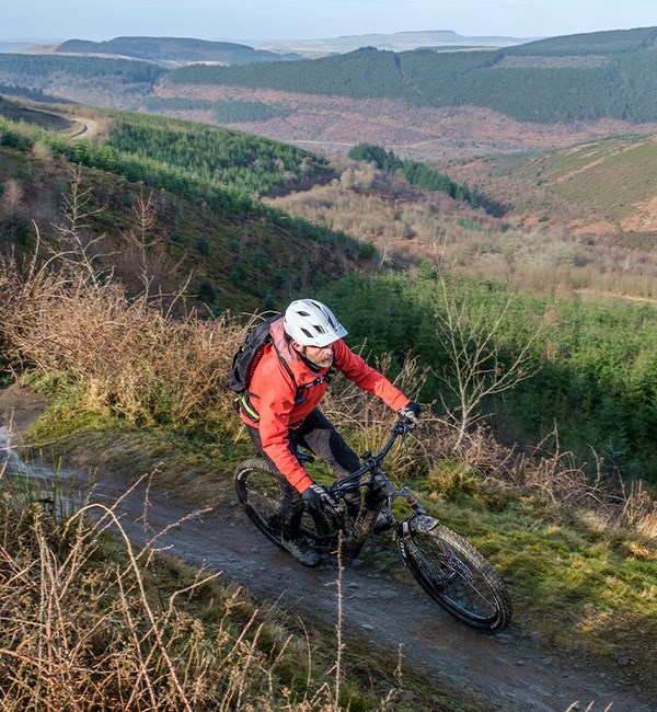 Mountain biker riding Cube Stereo Hybrid 160 HPC SLX in Welsh hills