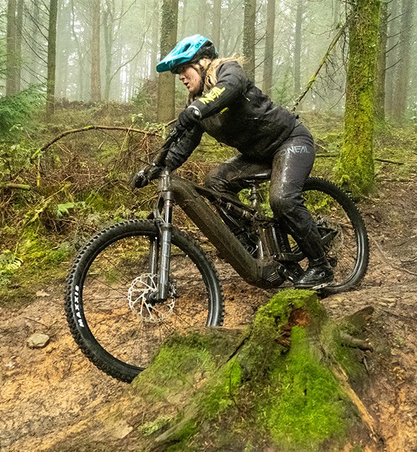 woman riding merida e-mtb in muddy woods
