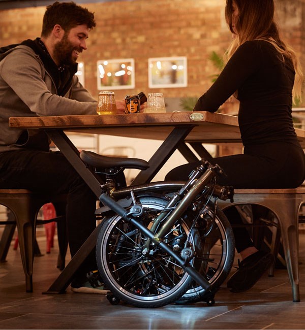 A Brompton, folded neatly under a table