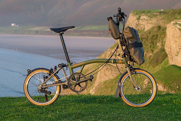 Brompton x Bear Grylls floding bike with luggage on the cliffs