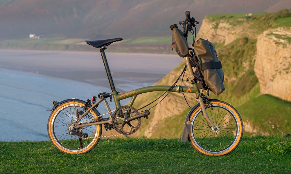 Brompton x Bear Grylls floding bike with luggage on the cliffs