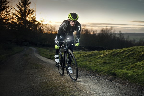 A road cyclist uses a powerful bar-mounted light to see the road ahead