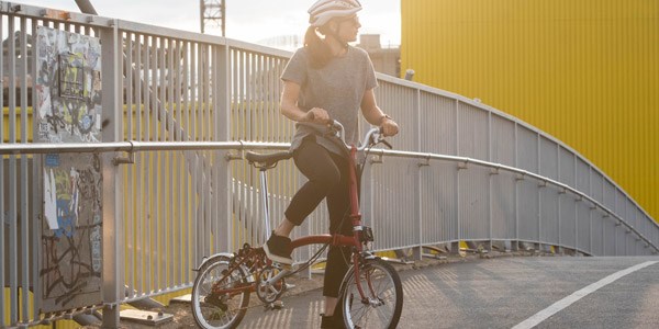 A cyclist riding through a city on a Brompton folding bike