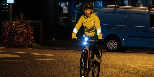 Two cyclists wear Endura jackets in bright colours with reflective detailing for good visibility, even on dark autumnal evenings