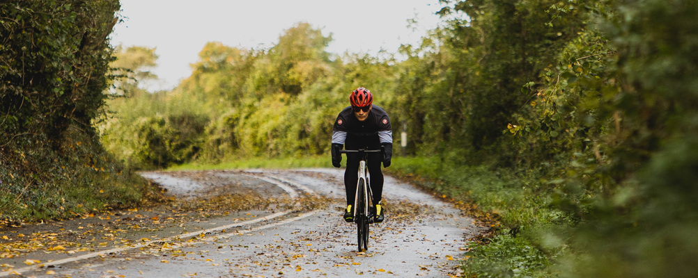 A cyclist riding along an autumnal cycle path