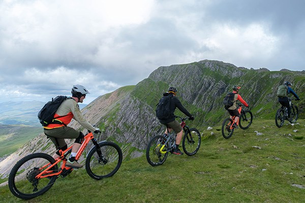 4 e-bikers riding welsh mountains