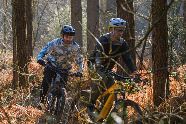 Two riders on Spcialized electric mountain bikes in the woods
