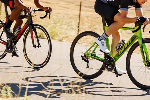 Two cyclists riding road race bikes